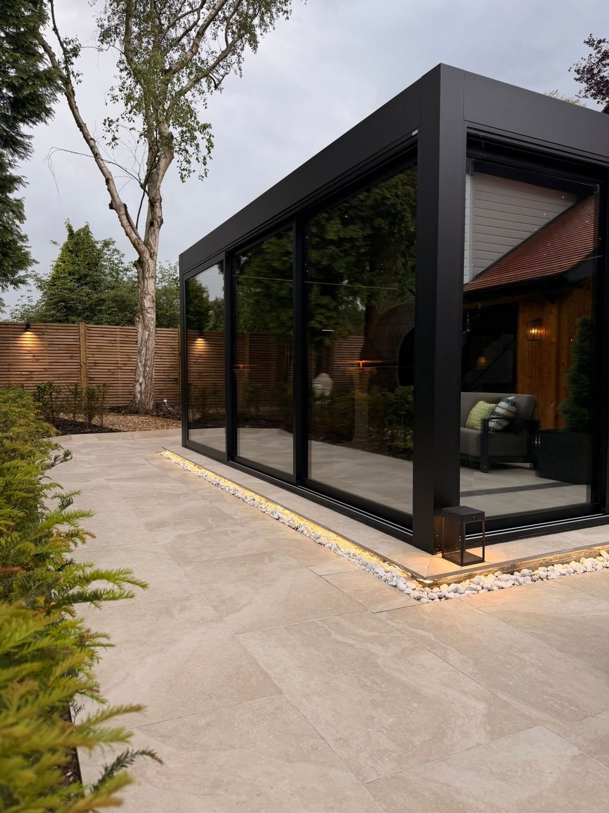 Contemporary garden room with feature lighting and stone patio, built by DB Landscapes Ltd in Stockport